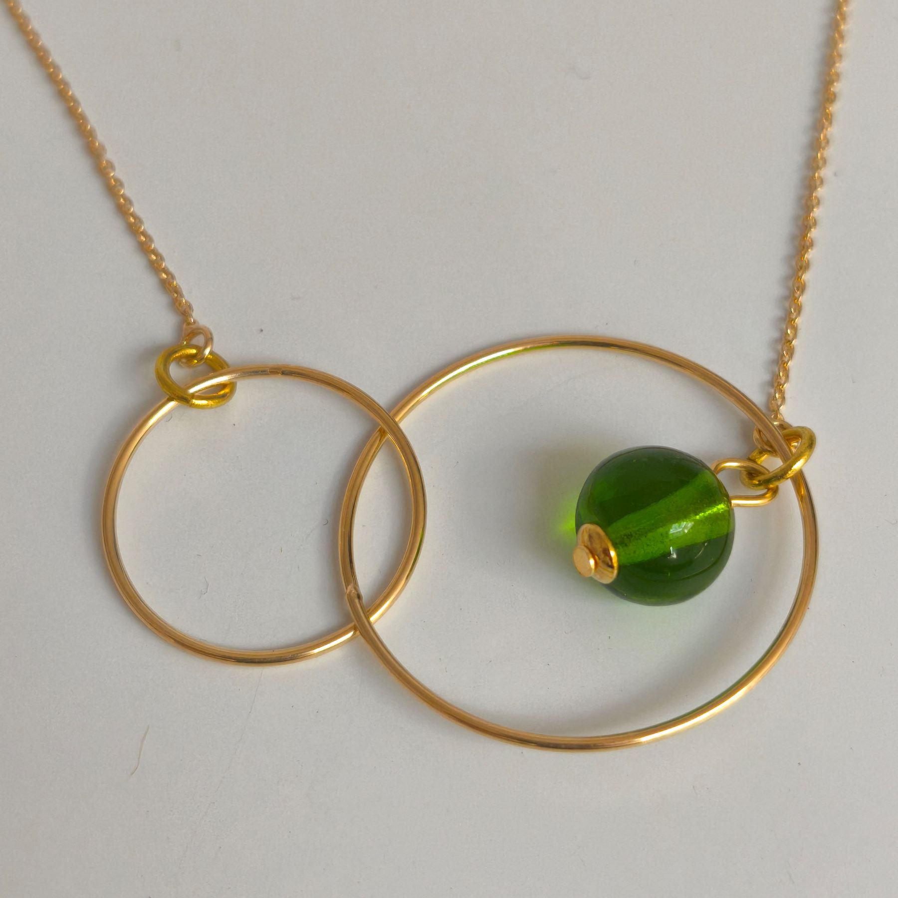 Collier toi et moi double anneau plaqué or avec perle en verre coloris vert transparent